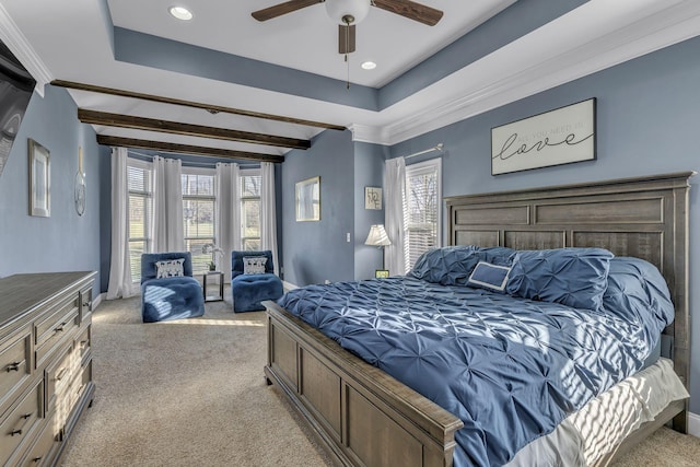 carpeted bedroom with beamed ceiling, a raised ceiling, ceiling fan, and crown molding