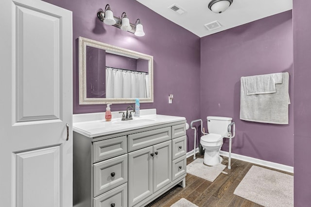 bathroom featuring wood-type flooring, vanity, and toilet