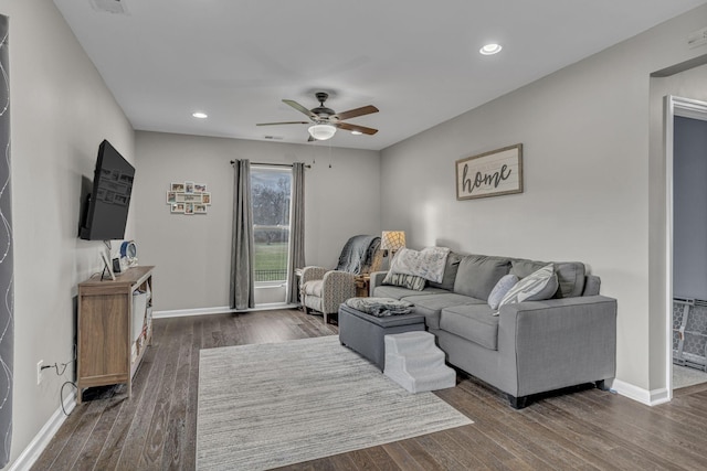 living room with ceiling fan and dark hardwood / wood-style flooring