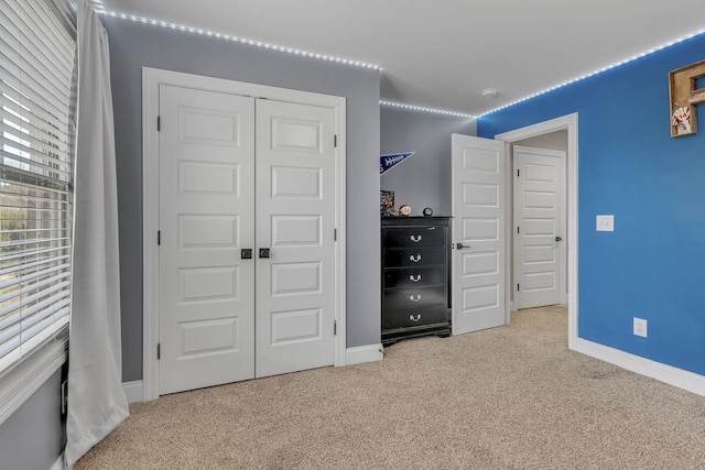 unfurnished bedroom featuring light carpet and a closet