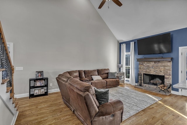 living room featuring ceiling fan, a fireplace, high vaulted ceiling, and hardwood / wood-style floors