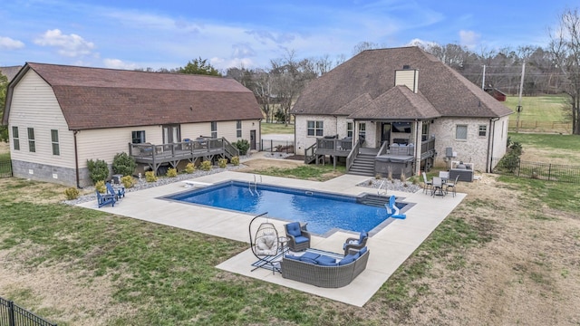 view of pool with outdoor lounge area, a yard, and a wooden deck