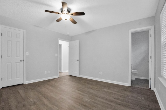 unfurnished bedroom featuring connected bathroom, ceiling fan, and dark hardwood / wood-style floors