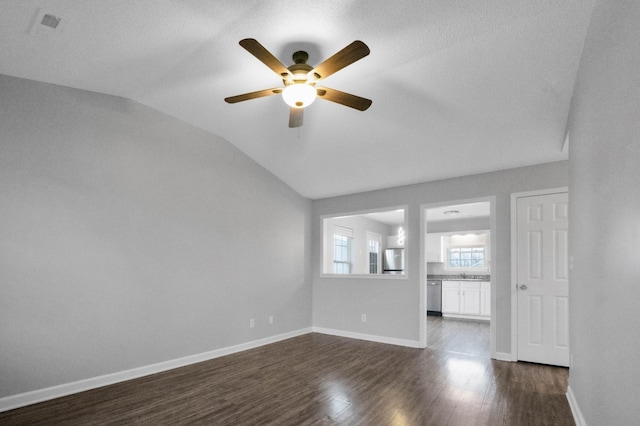 unfurnished living room with dark hardwood / wood-style floors, ceiling fan, lofted ceiling, and sink