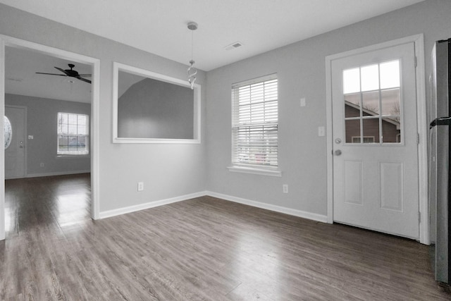 unfurnished dining area featuring ceiling fan, a healthy amount of sunlight, and dark hardwood / wood-style floors