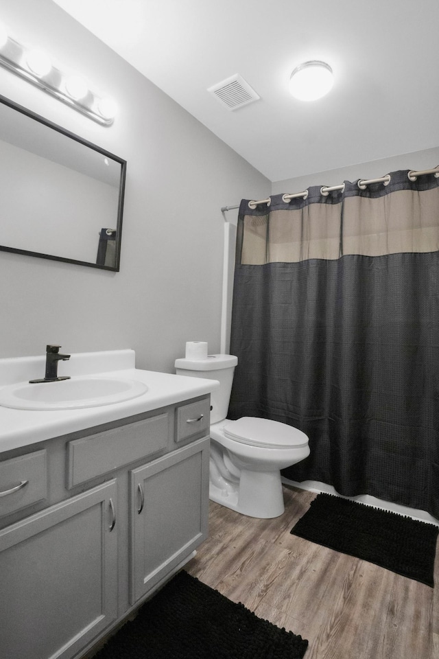 bathroom with a shower with shower curtain, vanity, toilet, and wood-type flooring