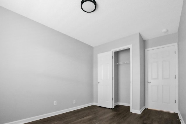 unfurnished bedroom featuring dark hardwood / wood-style flooring and a closet