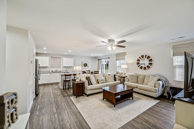 living room featuring ceiling fan and light hardwood / wood-style floors