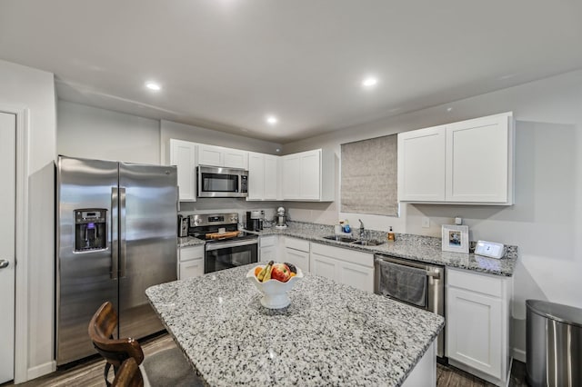 kitchen featuring white cabinets, sink, a center island, and stainless steel appliances