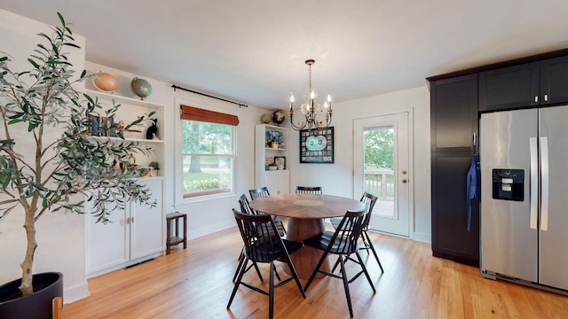 dining space featuring light hardwood / wood-style floors and a notable chandelier