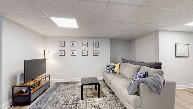 living room with light hardwood / wood-style flooring and a drop ceiling