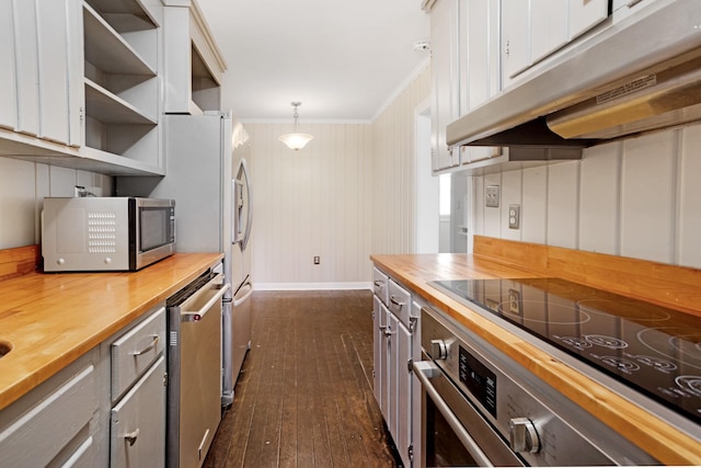 kitchen featuring pendant lighting, butcher block countertops, white cabinetry, and appliances with stainless steel finishes