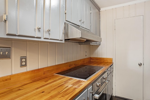 kitchen featuring wood counters, ornamental molding, electric stovetop, oven, and white cabinetry