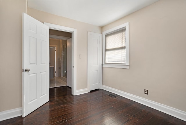 unfurnished bedroom with dark hardwood / wood-style flooring