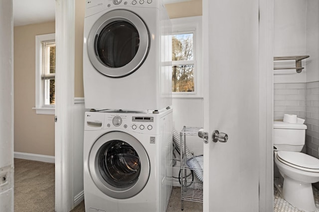 laundry room with carpet and stacked washing maching and dryer