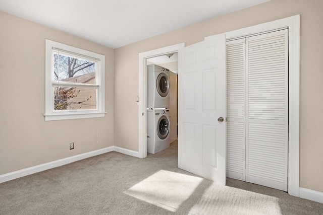 laundry room featuring stacked washer and dryer and light carpet