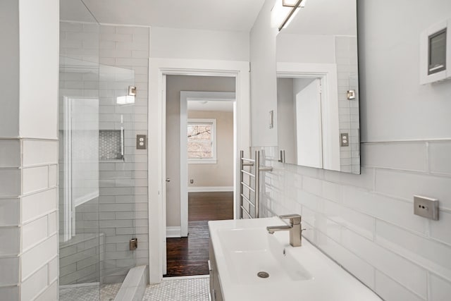 bathroom with vanity, tile patterned floors, an enclosed shower, and backsplash