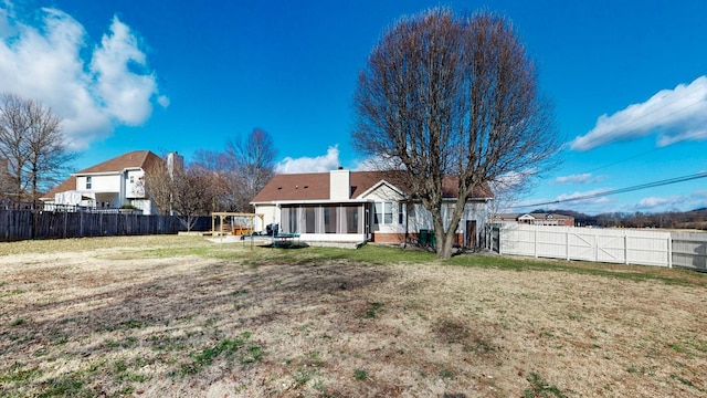 back of property with a lawn and a sunroom