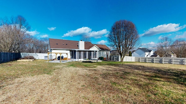 back of property with a yard, a patio area, and a sunroom