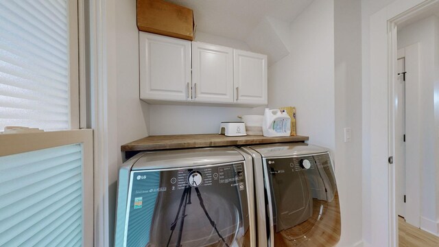 washroom with cabinets, separate washer and dryer, and light hardwood / wood-style flooring