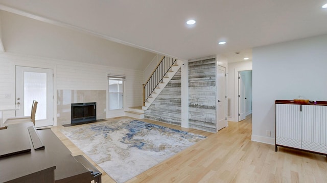 unfurnished living room featuring a tile fireplace and light wood-type flooring