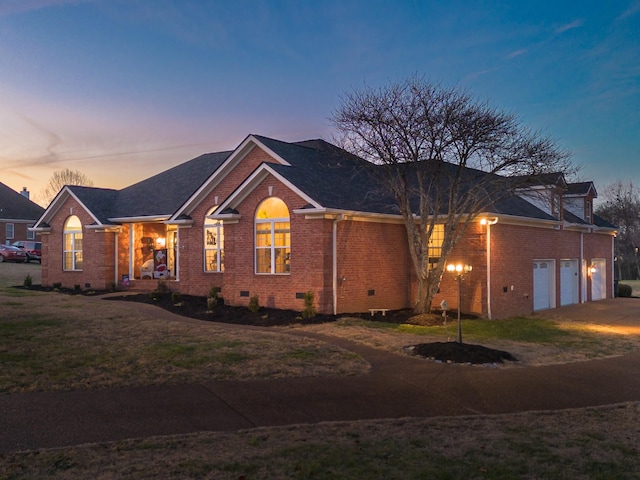 ranch-style home featuring a garage and a lawn