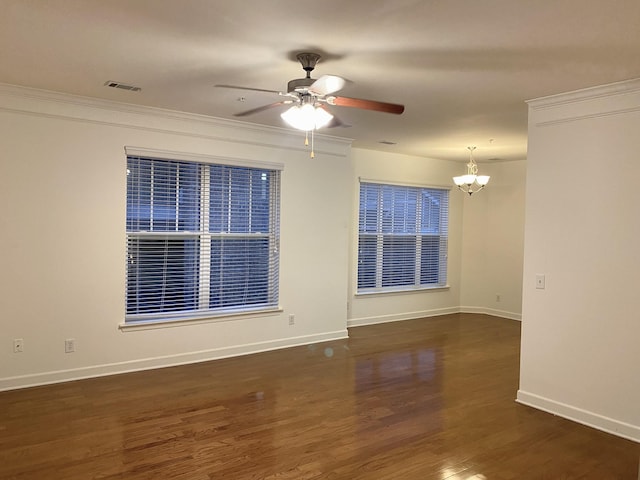 unfurnished room with dark hardwood / wood-style flooring, ceiling fan with notable chandelier, and crown molding