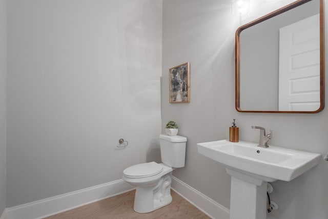 bathroom with hardwood / wood-style flooring and toilet