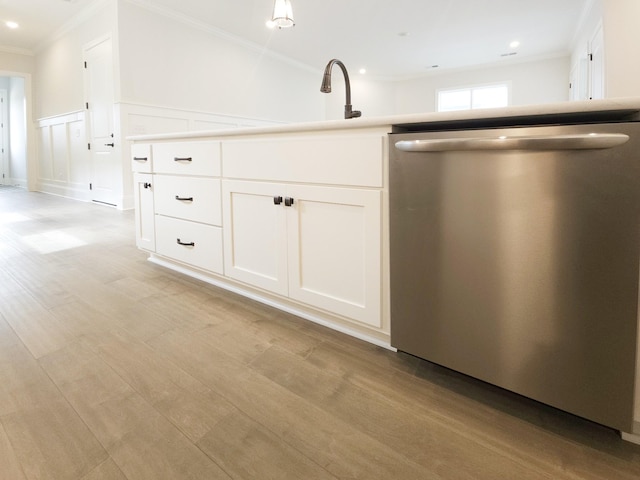 kitchen with white cabinets, stainless steel dishwasher, crown molding, and sink