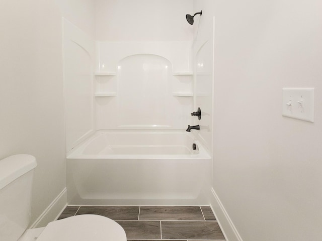 bathroom featuring washtub / shower combination and toilet