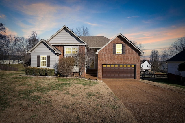 front of property with a garage and a yard