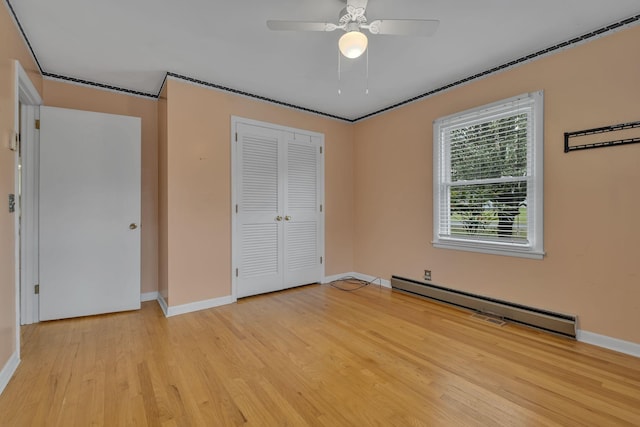 unfurnished bedroom featuring ceiling fan, a closet, light hardwood / wood-style floors, and a baseboard heating unit