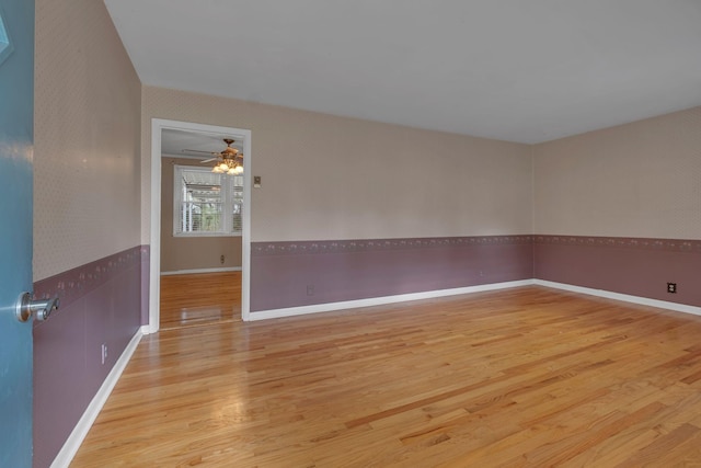 empty room featuring light wood-type flooring and ceiling fan