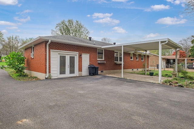 rear view of property featuring french doors and a carport