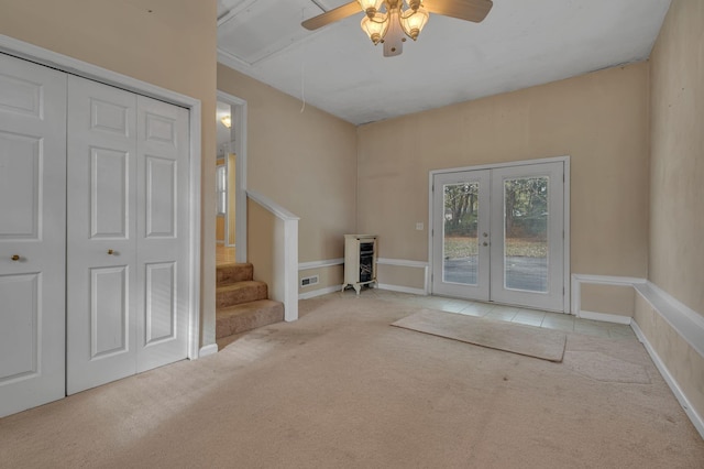 entryway with light carpet, french doors, and ceiling fan