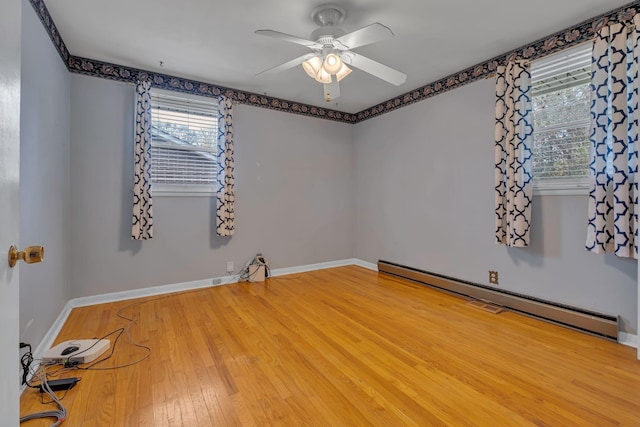 unfurnished room with ceiling fan, wood-type flooring, and a baseboard heating unit