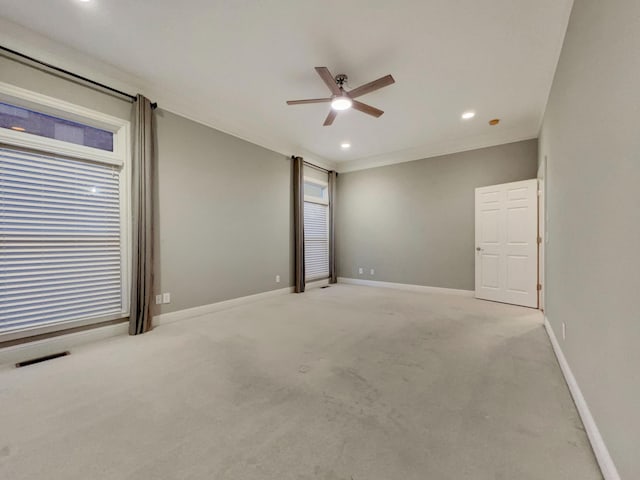 carpeted spare room featuring crown molding and ceiling fan