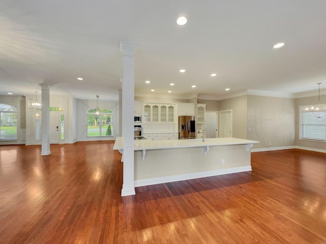 kitchen featuring hanging light fixtures, an inviting chandelier, a spacious island, and appliances with stainless steel finishes