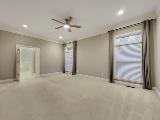 empty room with ceiling fan, light colored carpet, and ornamental molding