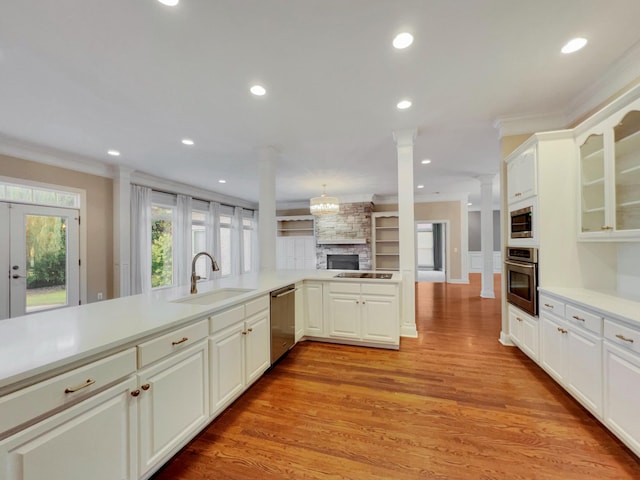 kitchen featuring sink, kitchen peninsula, ornamental molding, white cabinetry, and stainless steel appliances