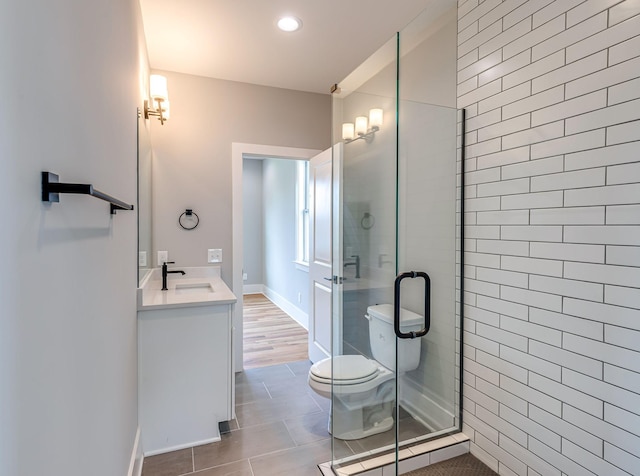 bathroom with tile patterned floors, vanity, toilet, and a shower with shower door