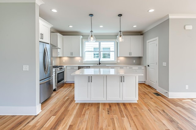 kitchen with pendant lighting, a kitchen island, white cabinetry, and appliances with stainless steel finishes