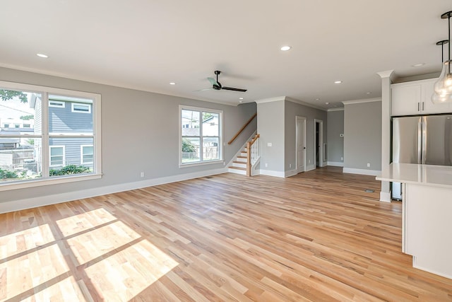 unfurnished living room with light hardwood / wood-style floors, ceiling fan, and crown molding