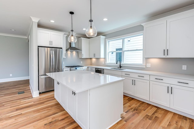 kitchen featuring appliances with stainless steel finishes, sink, pendant lighting, white cabinets, and a kitchen island