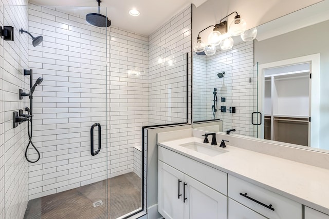 bathroom with a shower with door and vanity