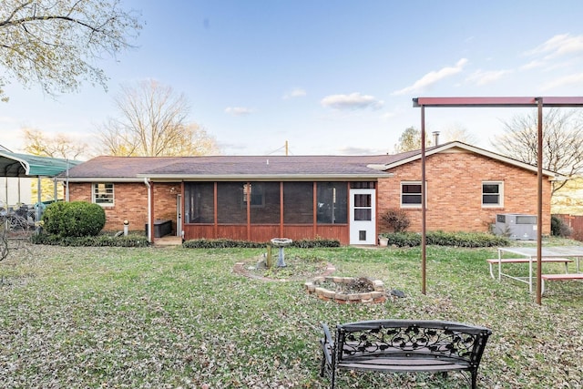 rear view of property featuring a sunroom and a lawn