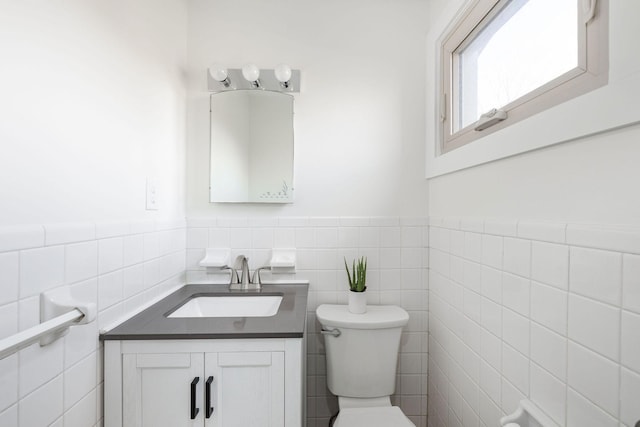 bathroom with vanity, tile walls, and toilet