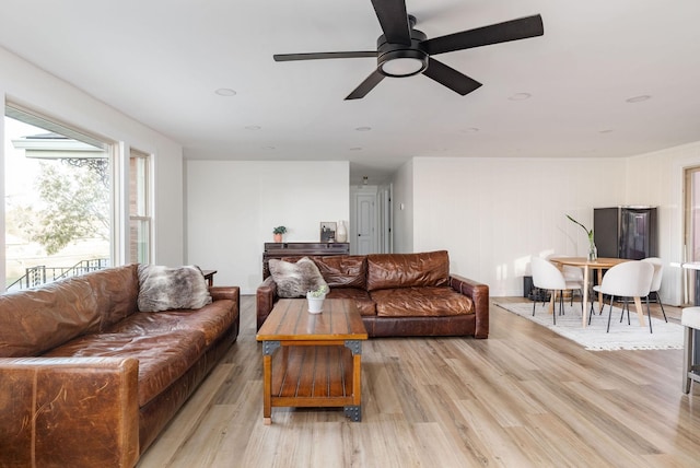 living room with ceiling fan and light wood-type flooring