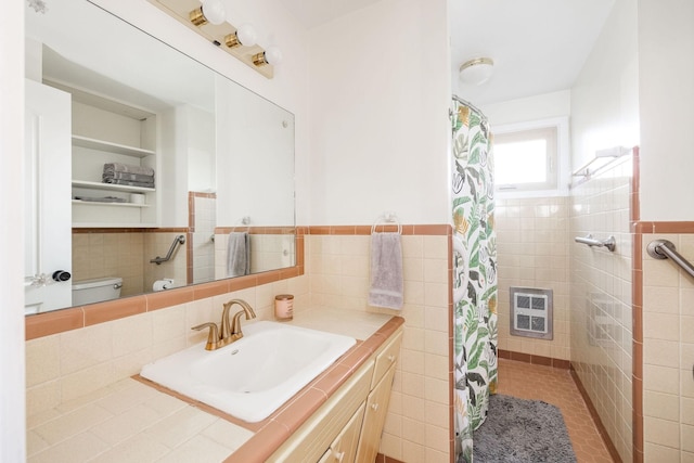 bathroom with vanity, heating unit, tile walls, and toilet