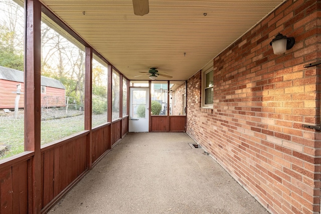 unfurnished sunroom featuring ceiling fan